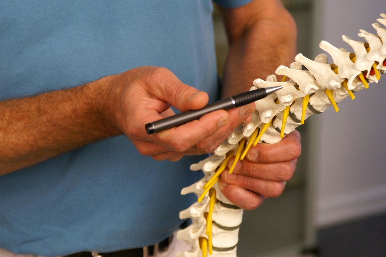 A man holding a pen and a skeleton.