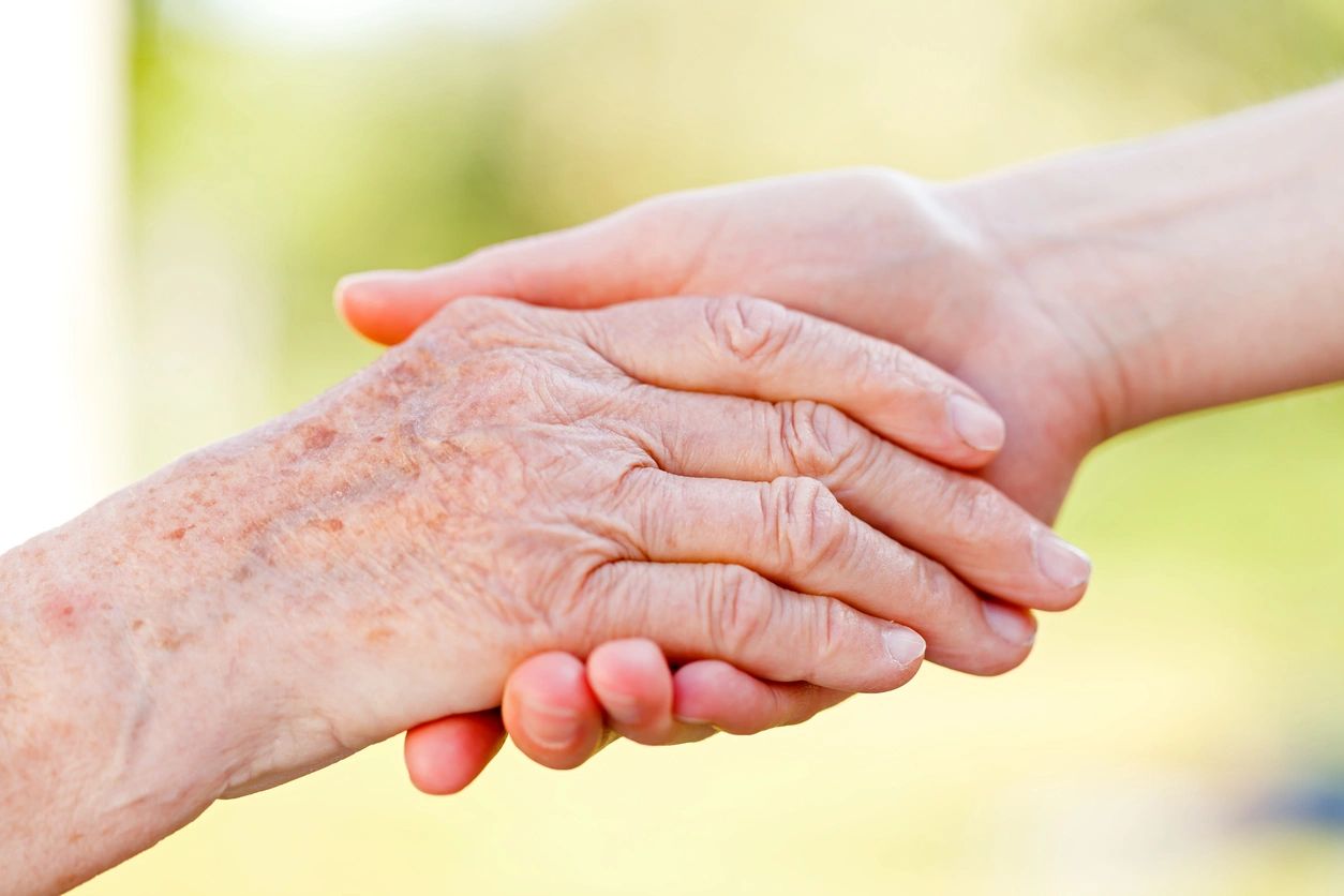 Two hands touching one another on a sunny day.